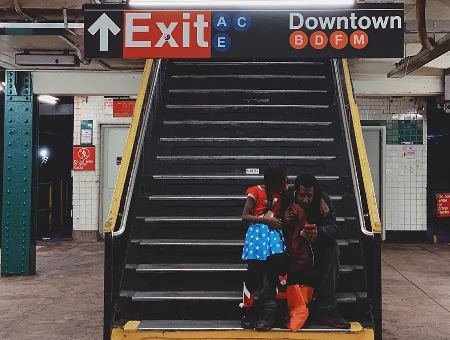 padre e hija escuchando un podcast en las escaleras del metro